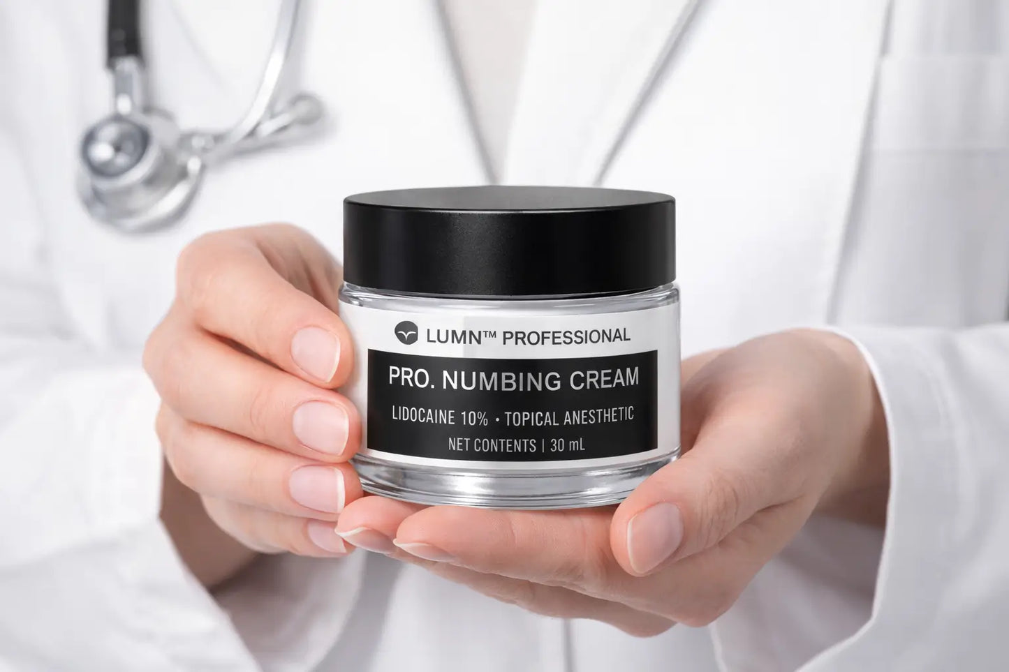dermatologist holding lumni professional lidocaine numbing cream used before microneedling treatments